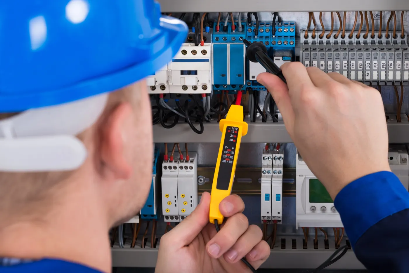 Électricien contrôlant un tableau électrique lors d'une mise aux normes en Île-de-France